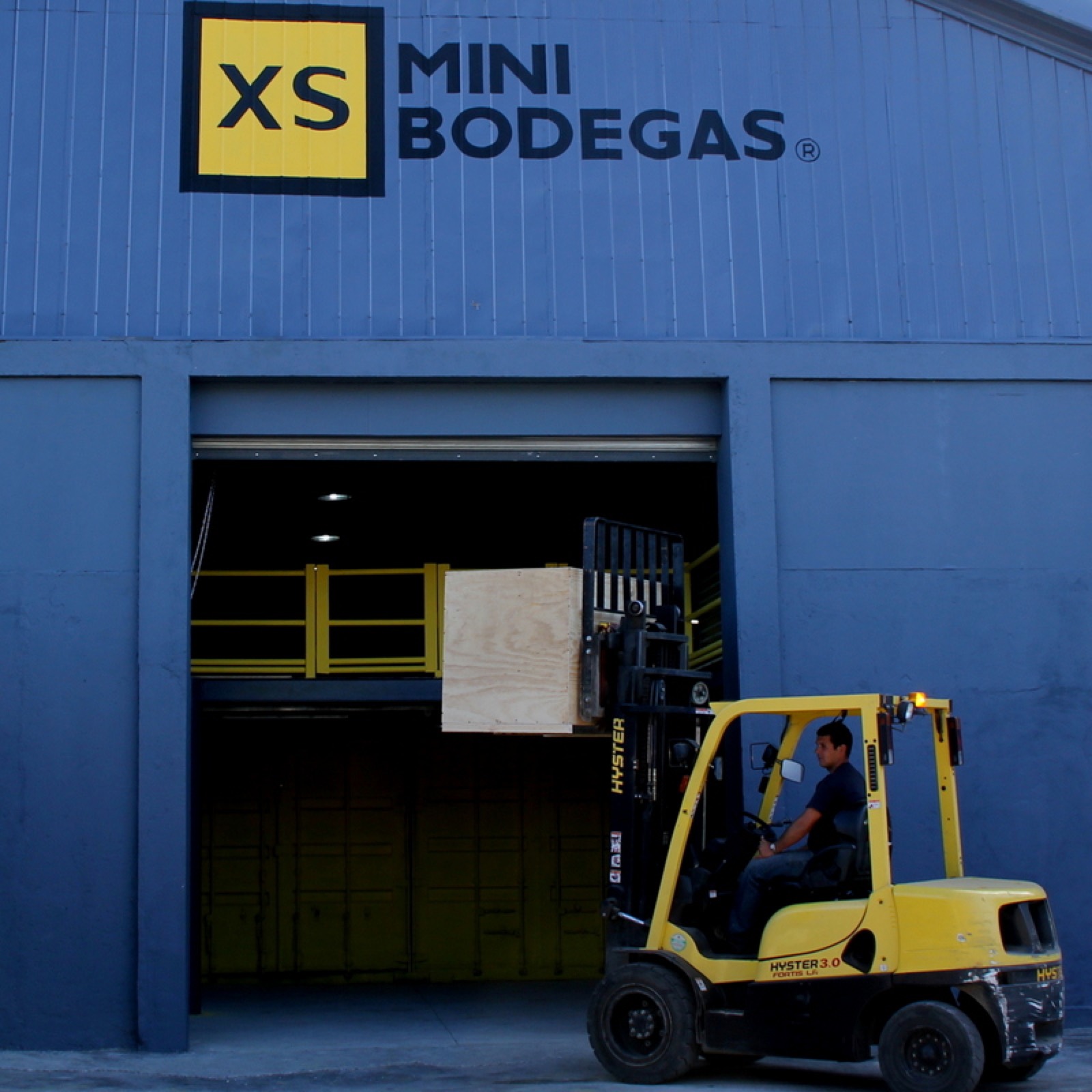 Grúa horquilla descargando mercadería en una bodega de XS Minibodegas